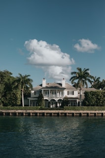 white concrete building near green trees and body of water during daytime