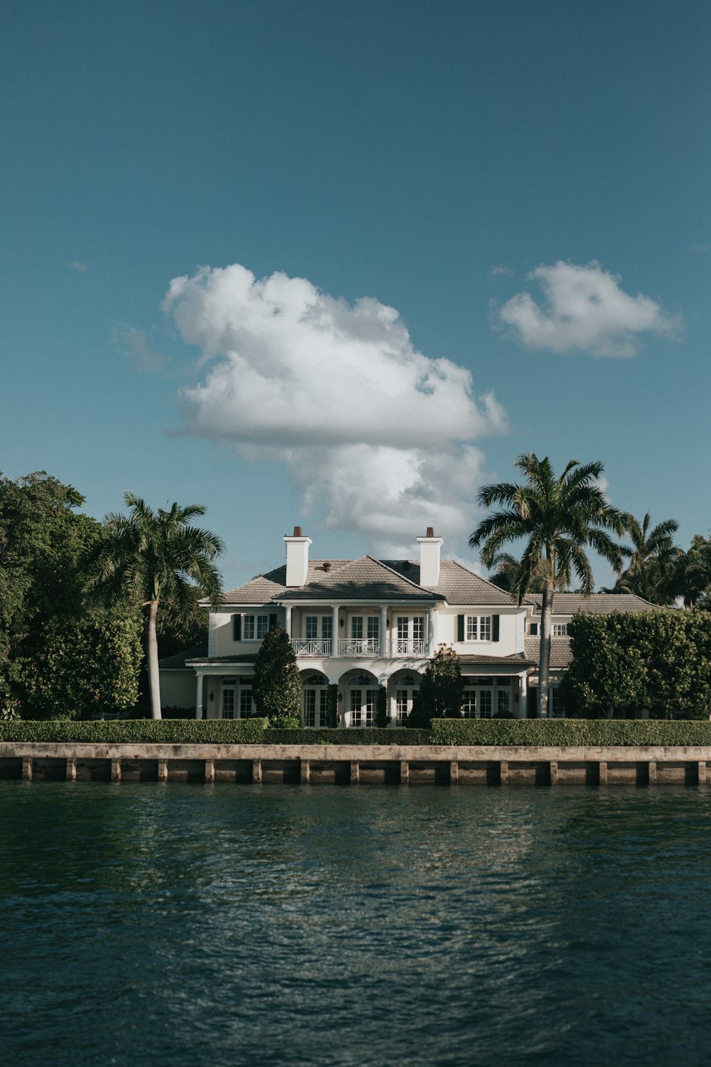 white concrete building near green trees and body of water during daytime