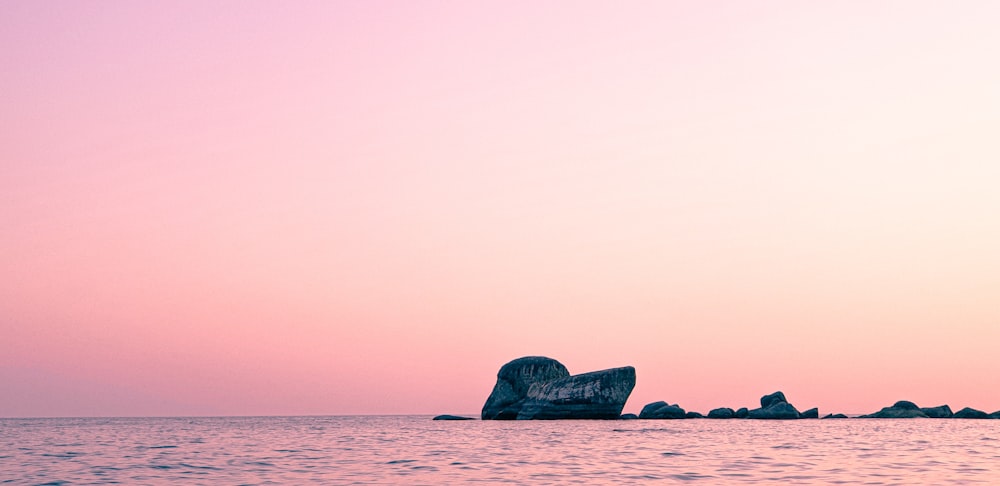 black rock formation on sea during daytime