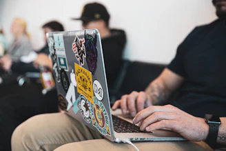 A multilingual freelancer working on a laptop with language flags floating around.