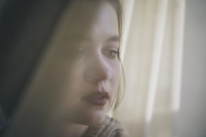 Casual candid shot of the same person outdoors, softly focused with rounded edges.