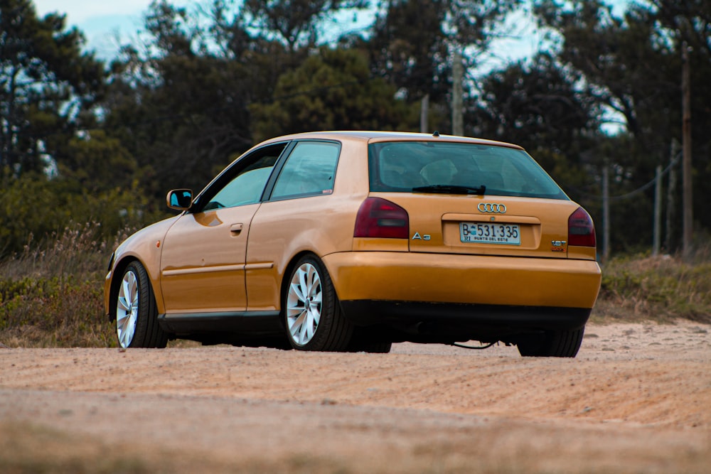 yellow sedan on brown dirt road during daytime