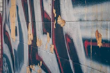 Close-up of a textured graffiti piece with layered spray paint and brush strokes