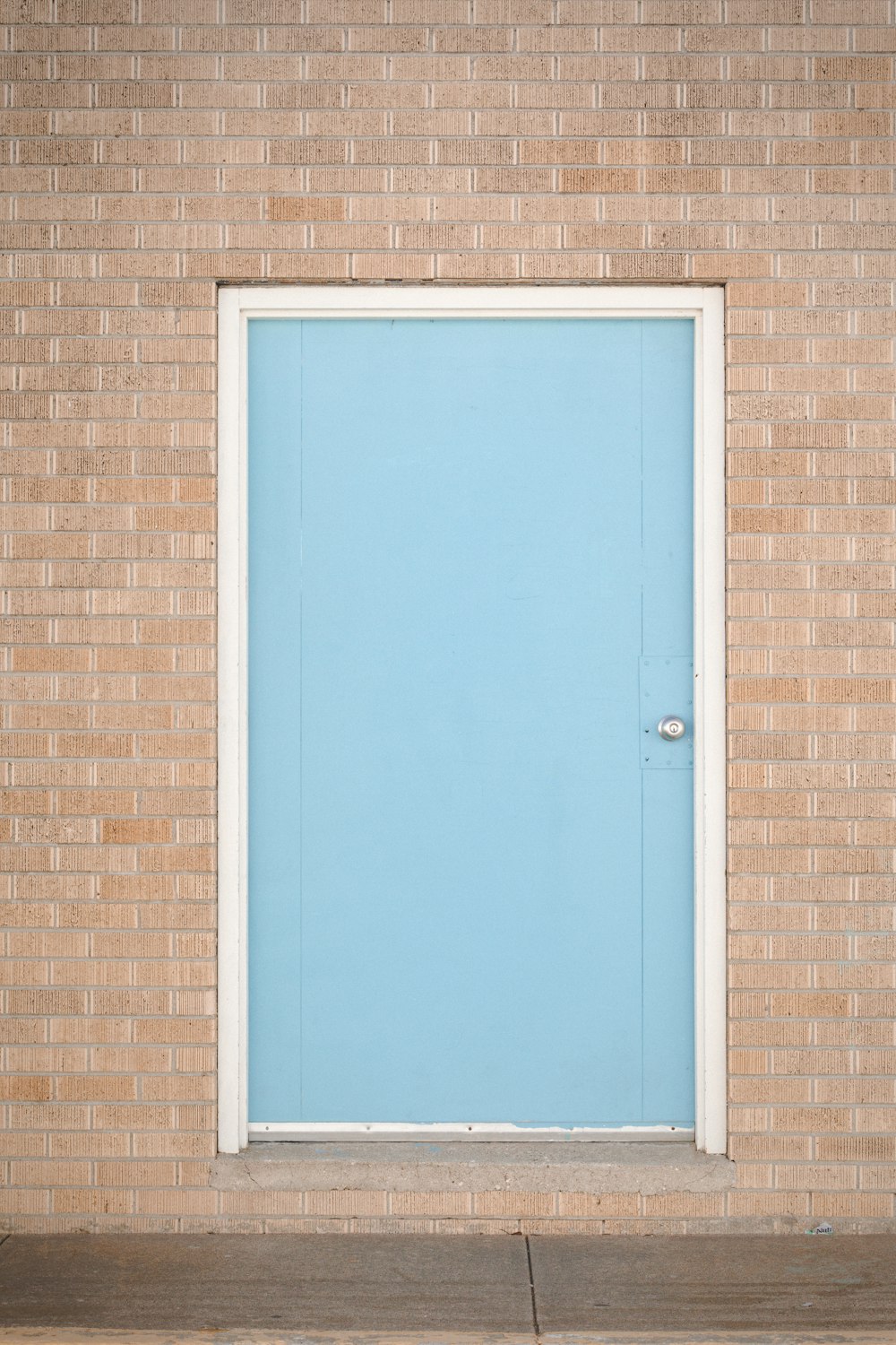 blue wooden door on brown brick wall