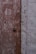 Two adjoining doors with a weathered appearance, one brown and one gray. The finish is distressed with visible signs of wear and peeling paint. A round metal doorknob is present on the brown door.