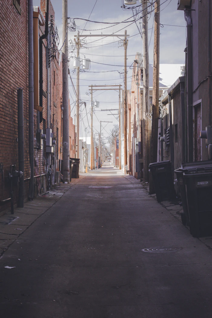 An empty street between brown brick buildings