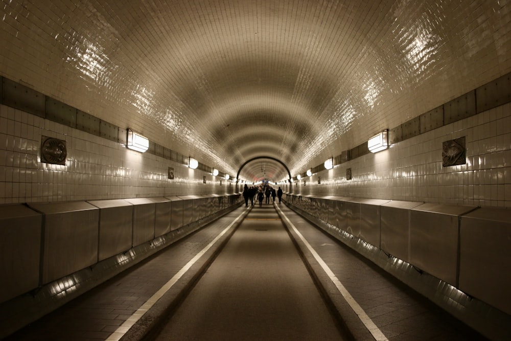 gray and white tunnel with lights turned on during night time