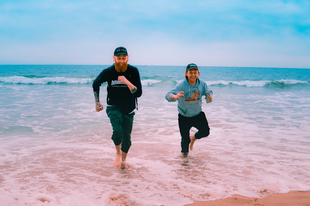 man and woman standing on beach during daytime