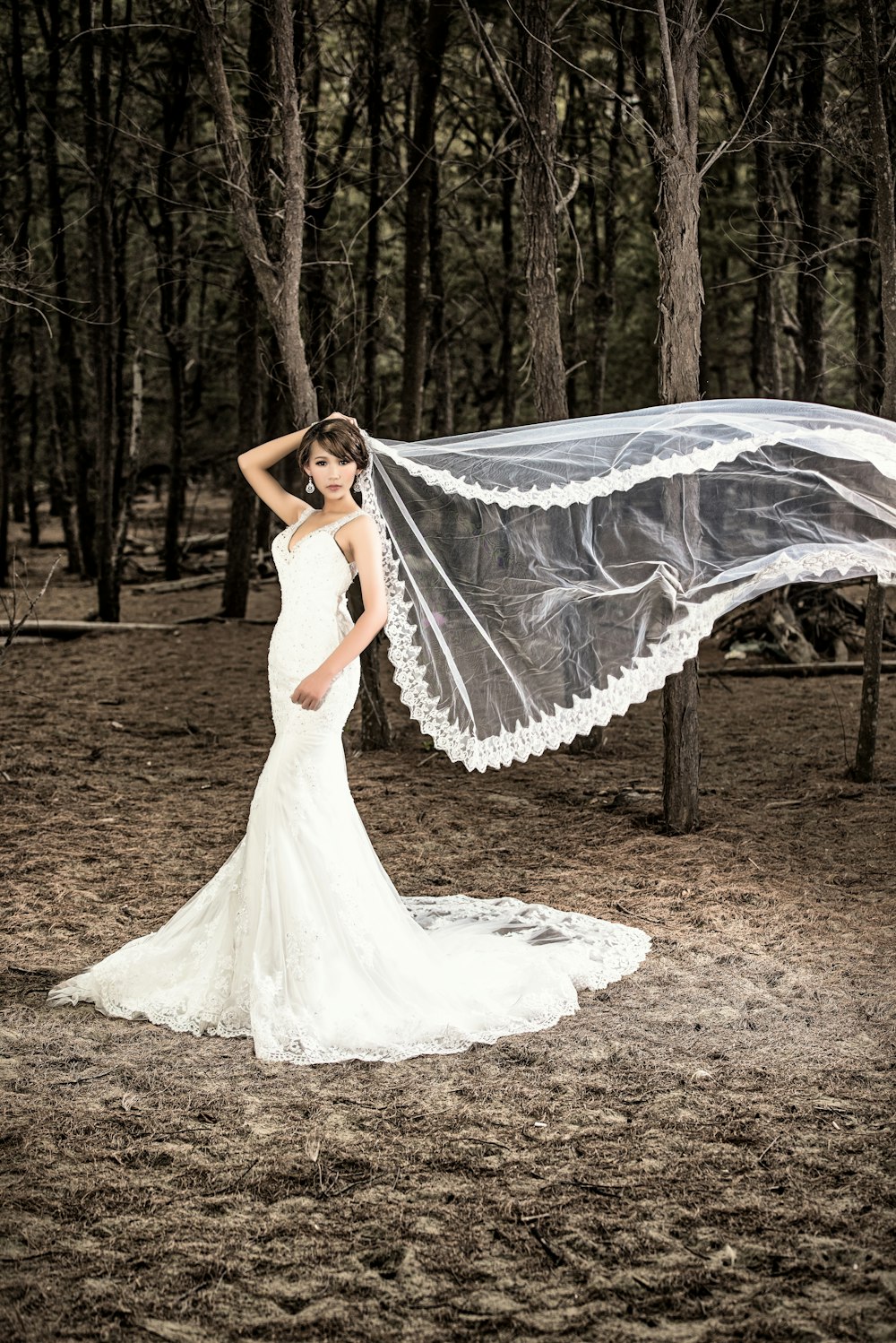 woman in white wedding dress standing on brown soil