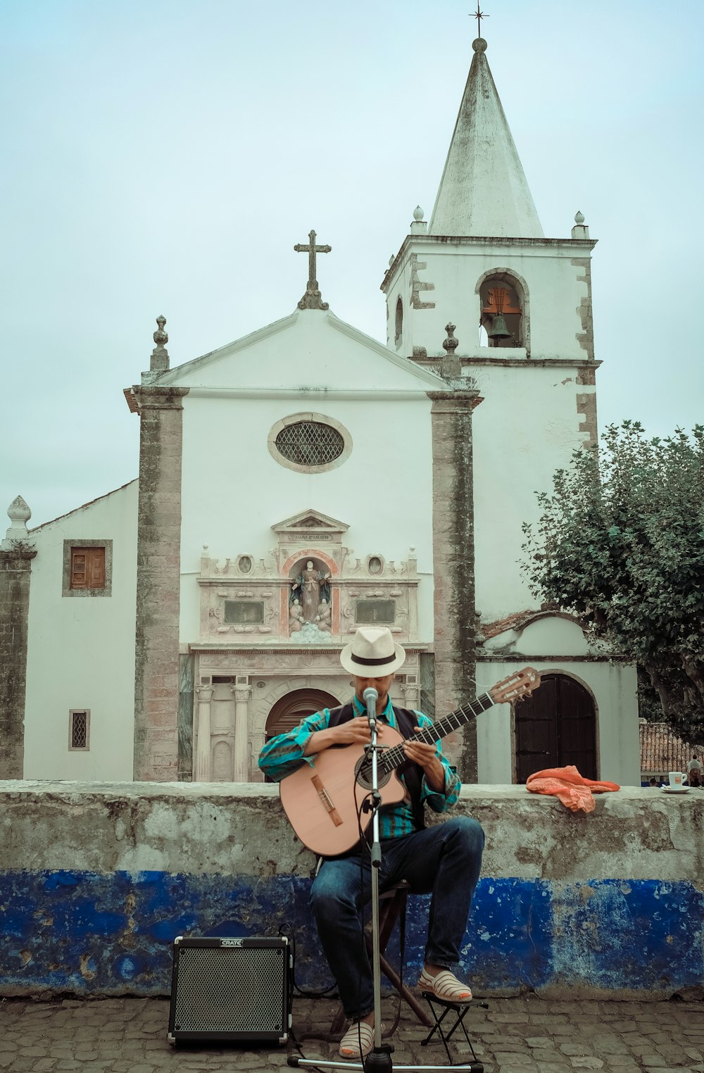 파란색 데님 청바지를 입은 남자가 갈색 어쿠스틱 기타를 연주