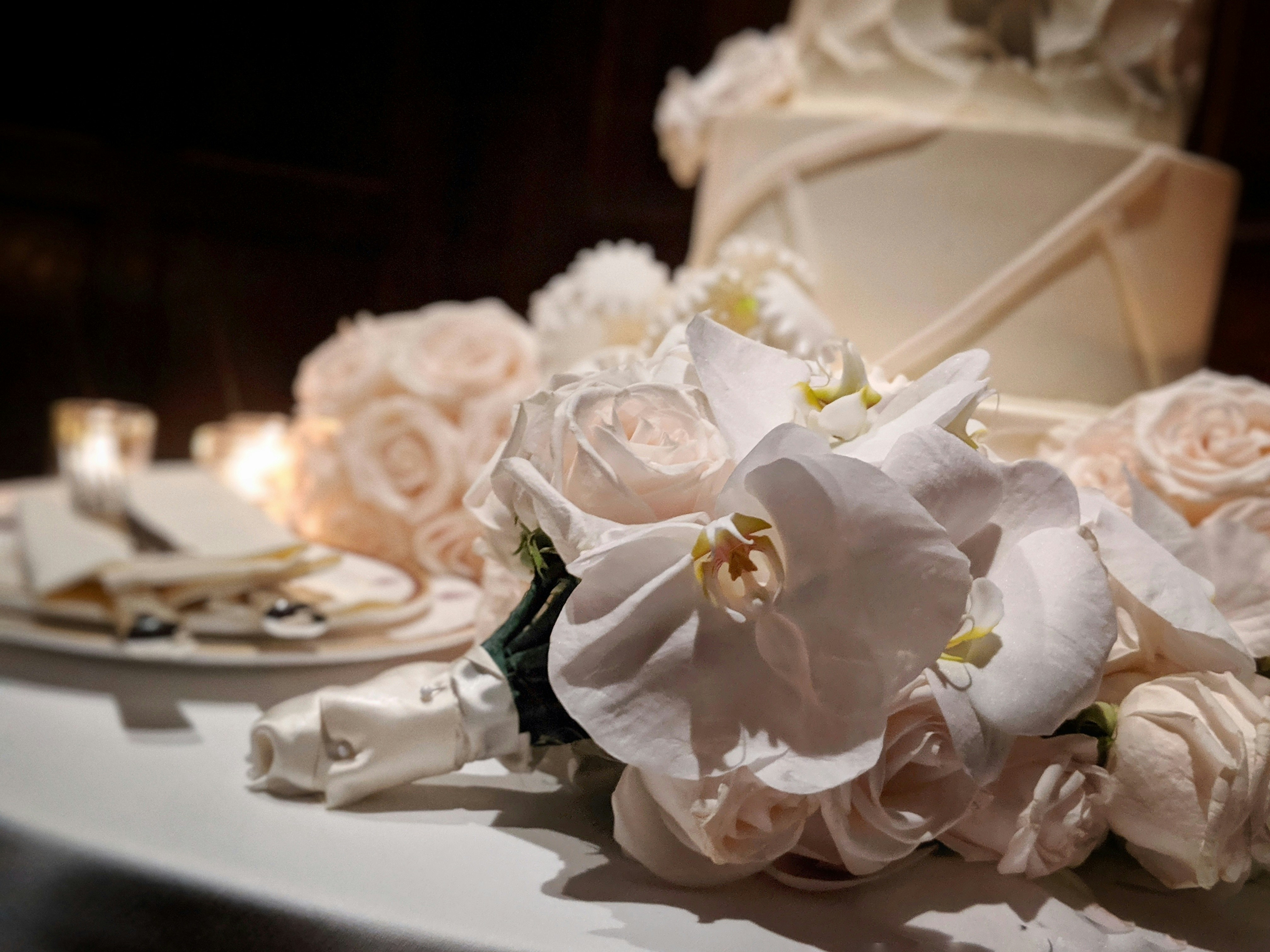 Wedding cake table with white tiered cake and fresh flower decorations
