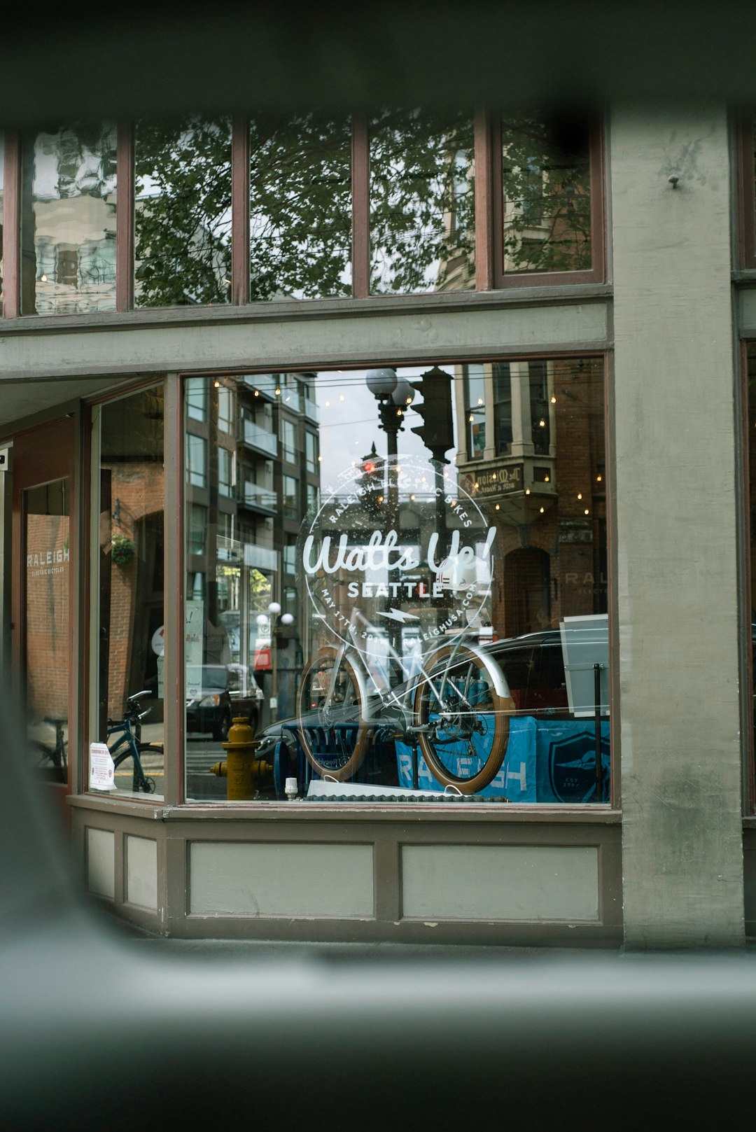 blue bicycle parked beside glass window