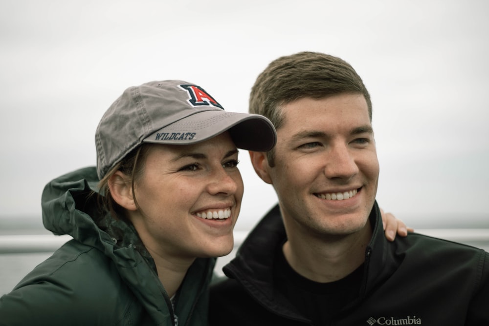 man in black jacket beside woman in green jacket