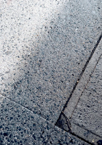Close-up of freshly paved asphalt surface glistening under sunlight