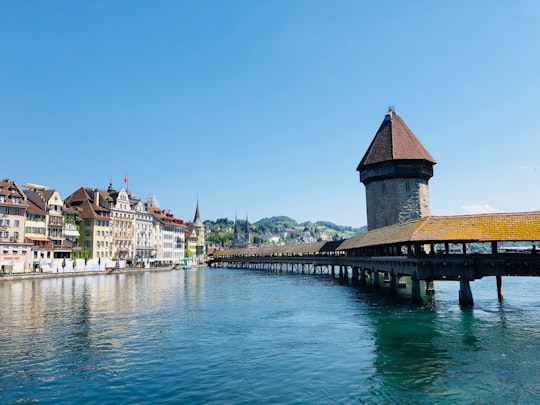 brown wooden dock on body of water during daytime in Kapellbrücke Switzerland