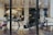 A vintage-style bicycle is placed inside a modern showroom with large windows. The interior features comfortable, minimalist furniture including chairs and a sofa. Soft lighting creates a cozy and inviting atmosphere with an elegant, urban aesthetic.