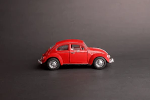 Side view of a pastel blue Beetle with whitewall tires against a minimalist white background