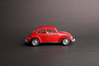 Side view of a pastel blue Beetle with whitewall tires against a minimalist white background