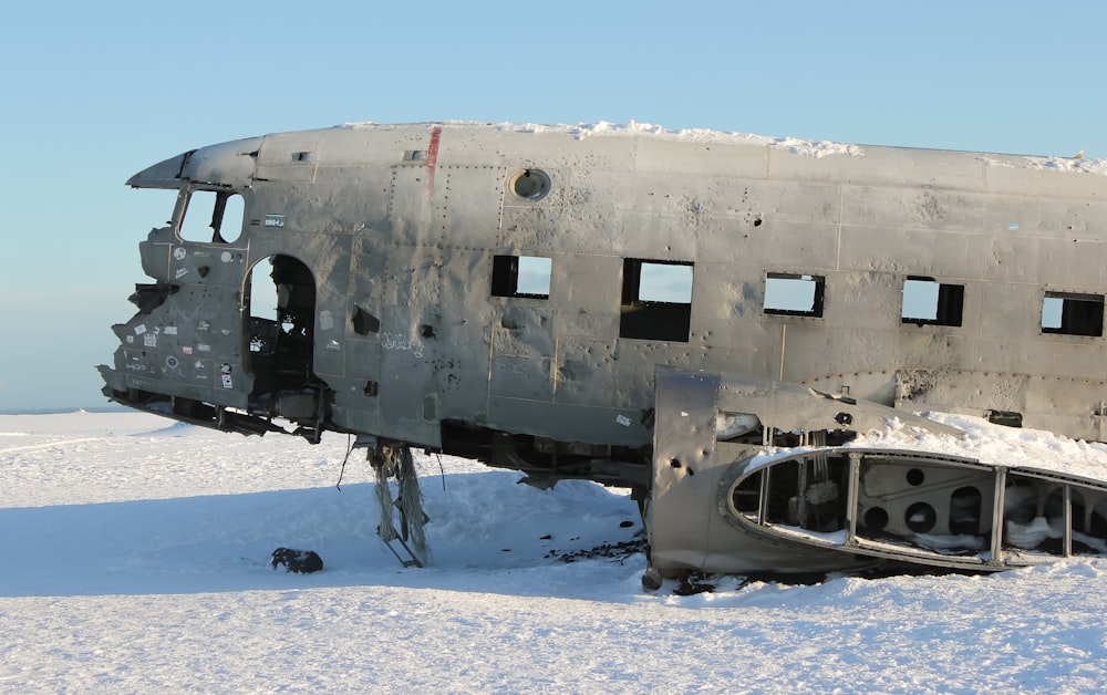 white and black airplane on snow covered ground during daytime