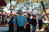 Visitors enjoying a sunny day at the local market with colorful stalls and fresh produce