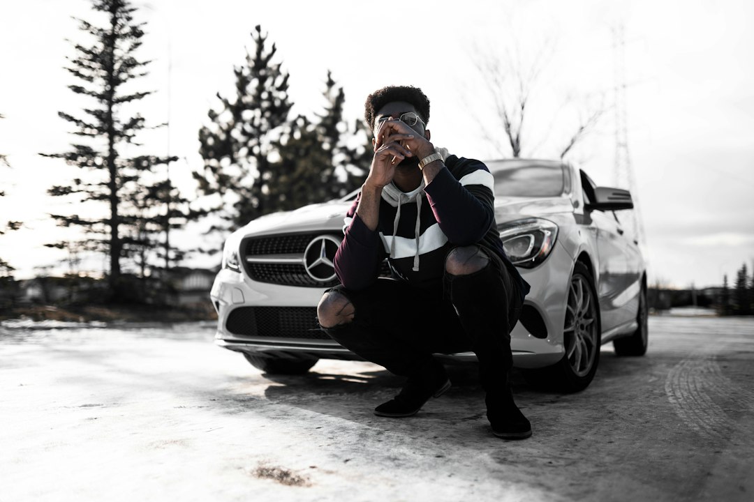 man in black jacket and black pants sitting on black car, Recording artist Muna (@MunaIsBlack)<p></figure>Instagram: @VisualsByRoyalZ