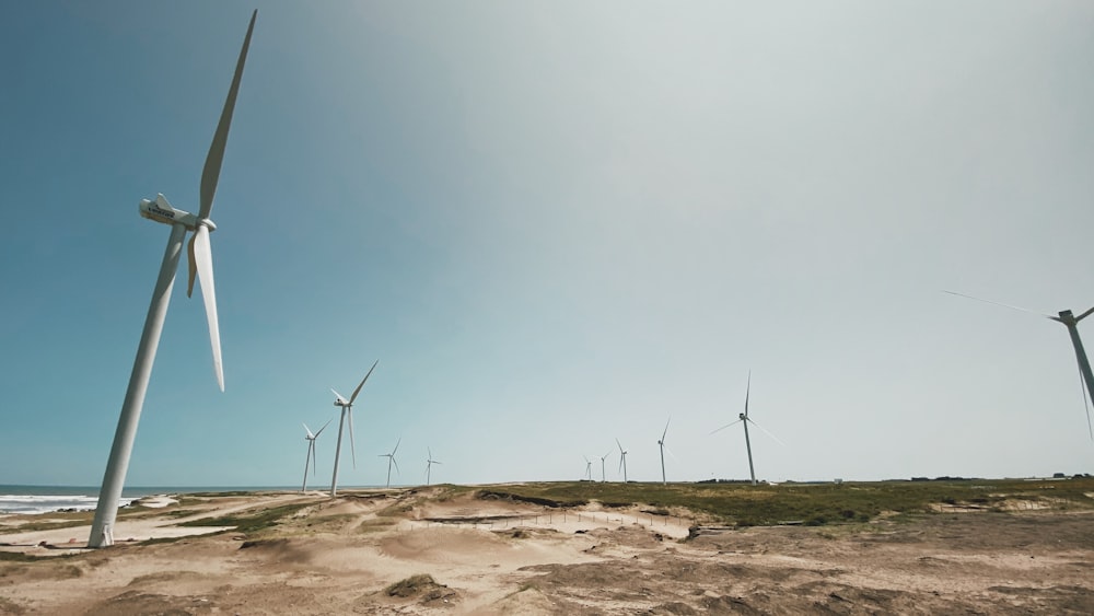turbine eoliche su sabbia marrone sotto cielo blu durante il giorno