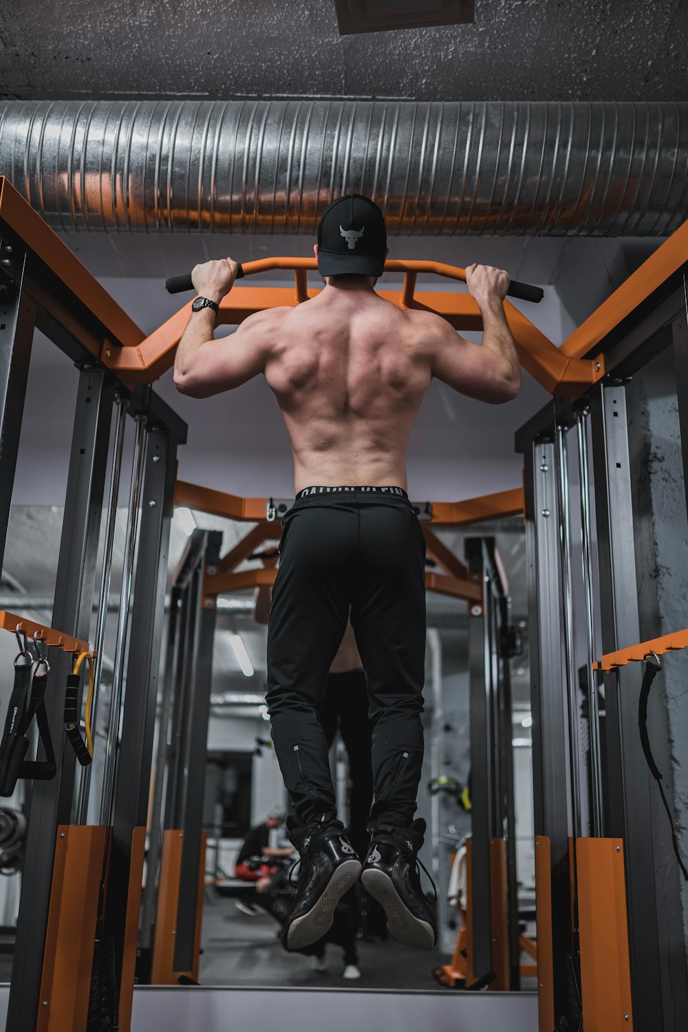 topless man in black pants and black nike shoes