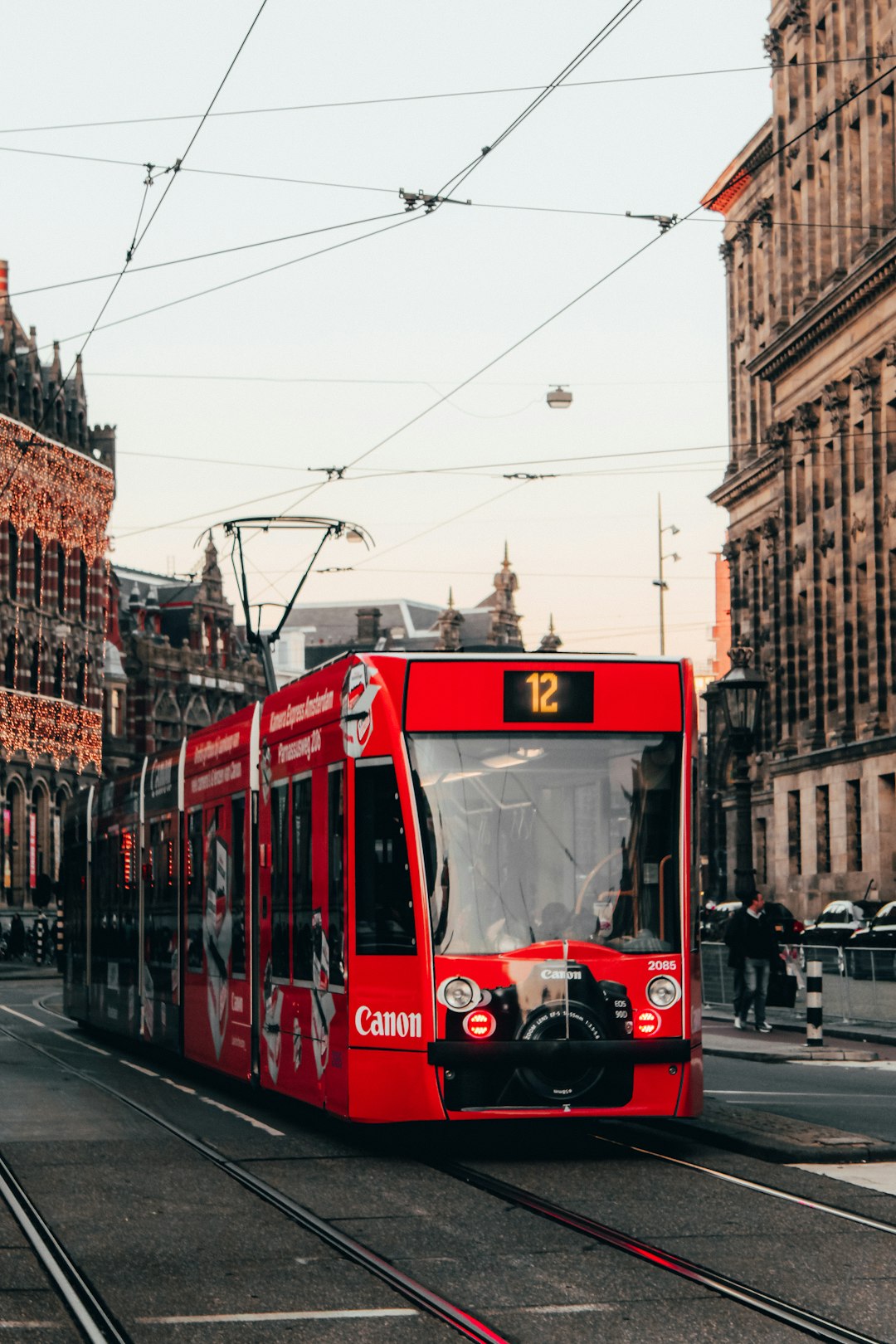 red tram on road during daytime