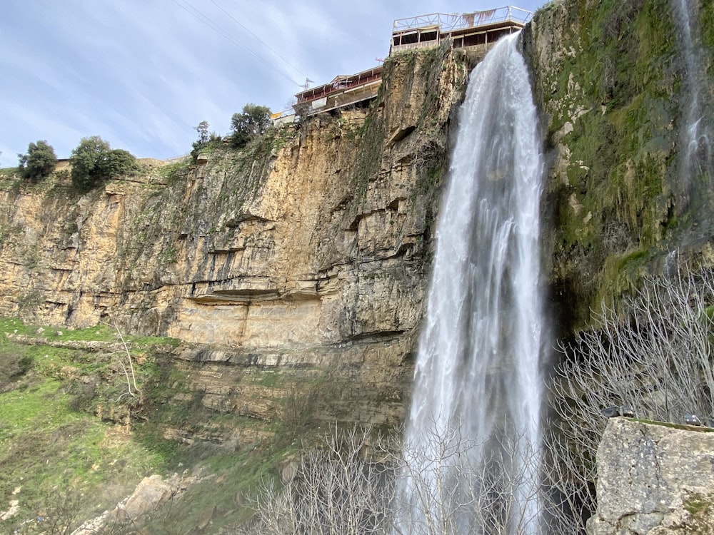 waterfalls on rocky mountain under blue sky during daytime