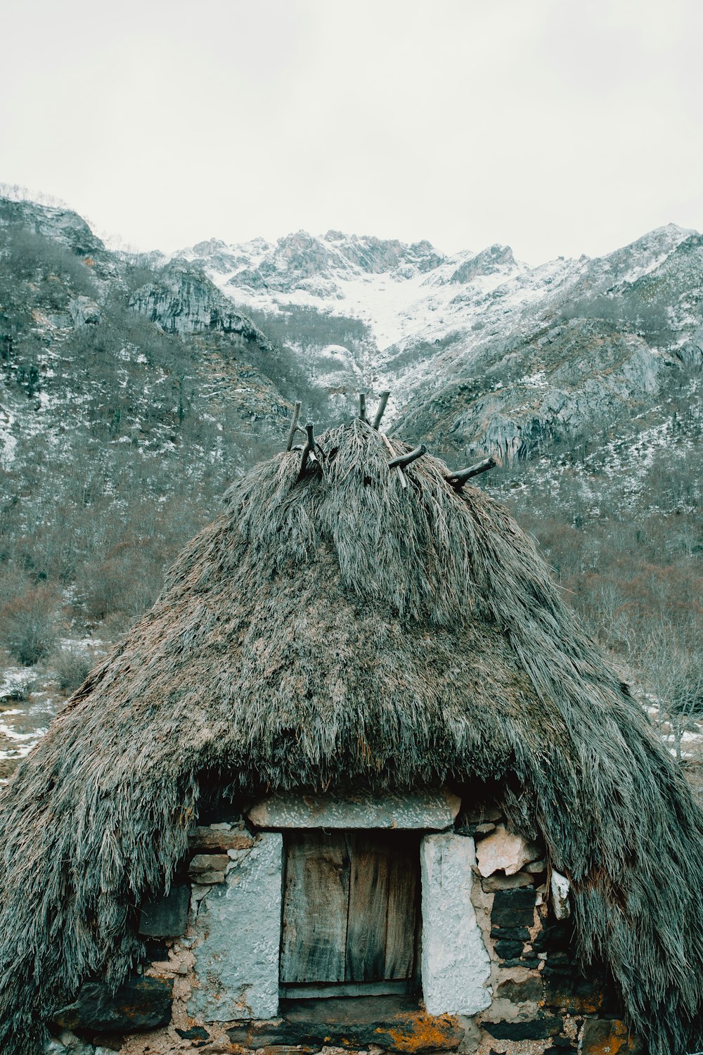 Braunes Holzhaus in der Nähe des schneebedeckten Berges tagsüber