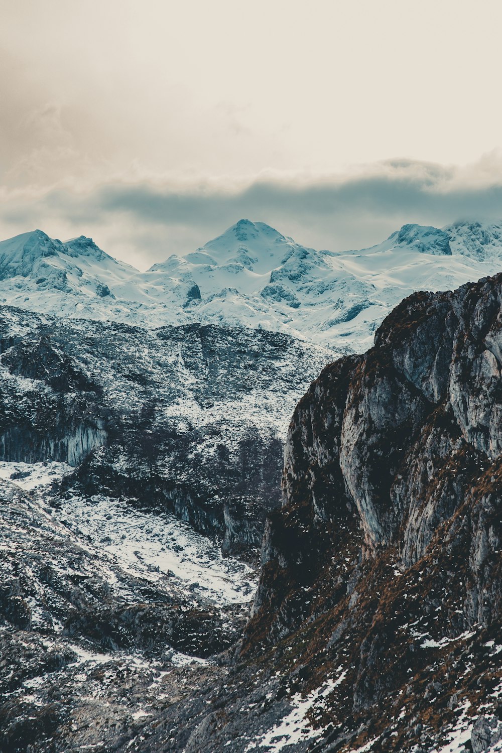 snow covered mountain under cloudy sky during daytime