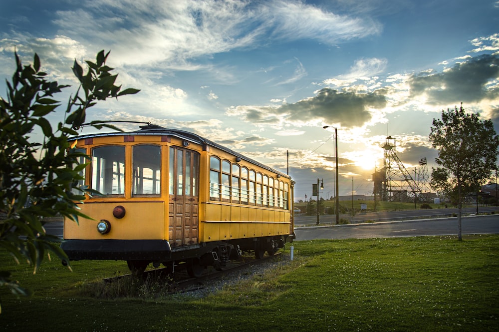 trem amarelo na estrada de ferro sob o céu nublado durante o dia