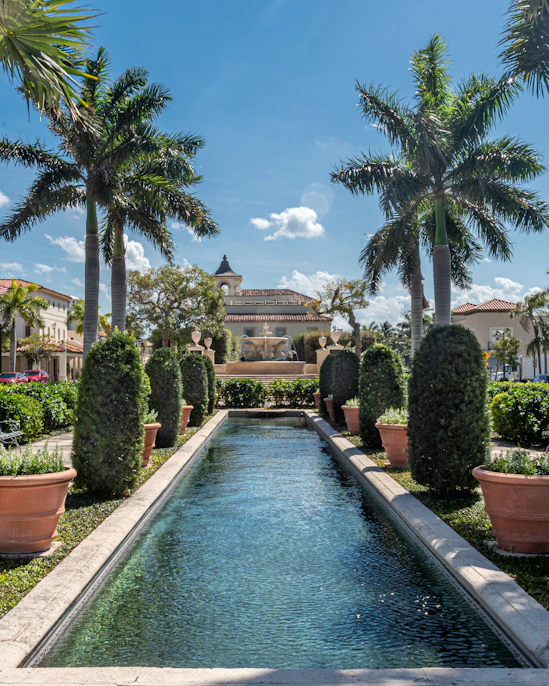 green trees near swimming pool near large homes during daytime