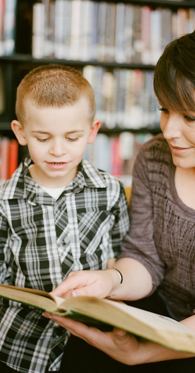 boy in gray sweater beside boy in gray and white plaid dress shirt