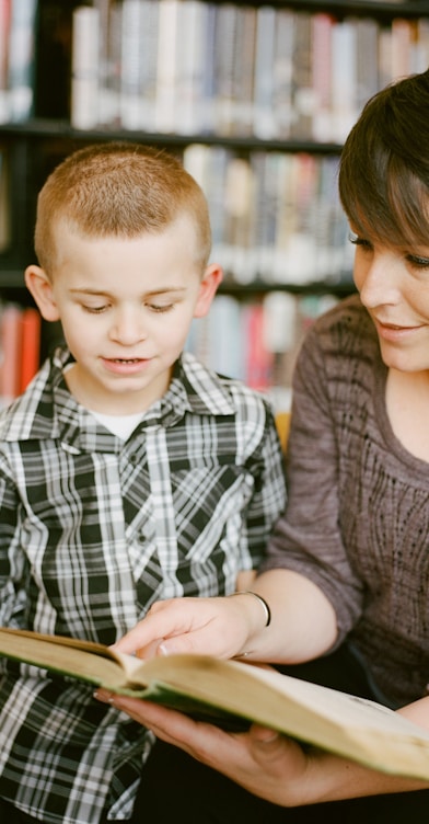 boy in gray sweater beside boy in gray and white plaid dress shirt