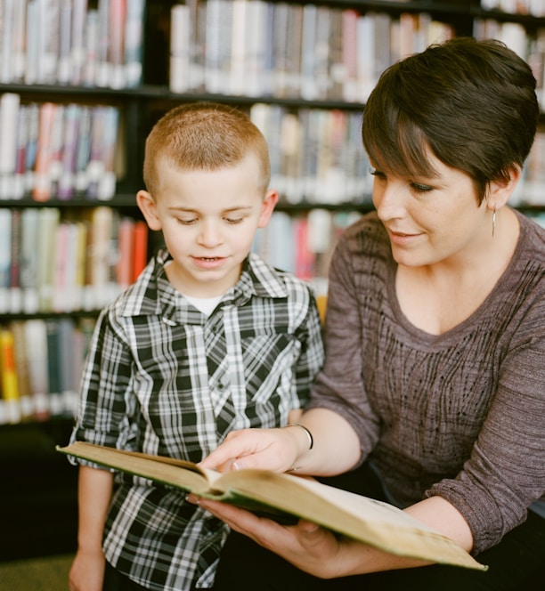 boy in gray sweater beside boy in gray and white plaid dress shirt