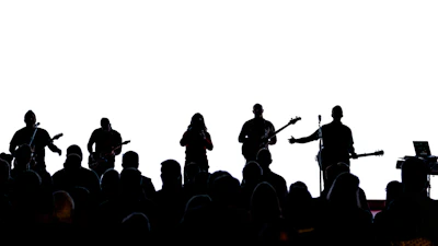 Wide shot of the stage with band silhouettes against a black backdrop.