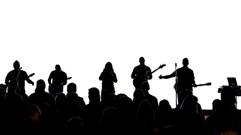 silhouette of people standing on top of mountain