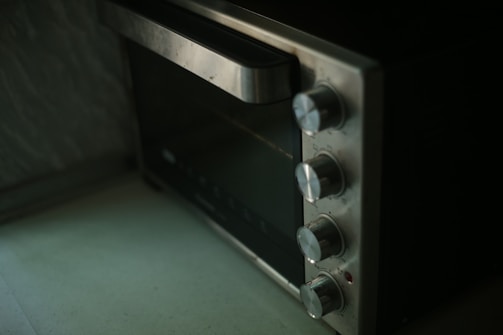 Close-up of a technician inspecting an oven range.