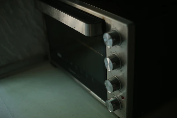 Close-up of a modern microwave with its door open, showing clean interior and control panel.