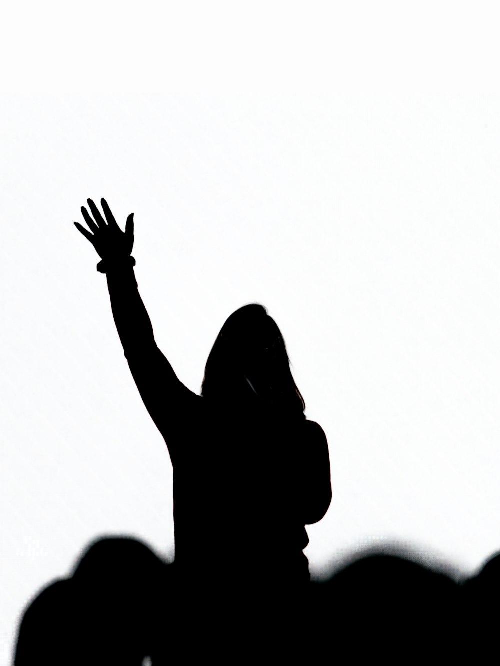 silhouette of person raising hand