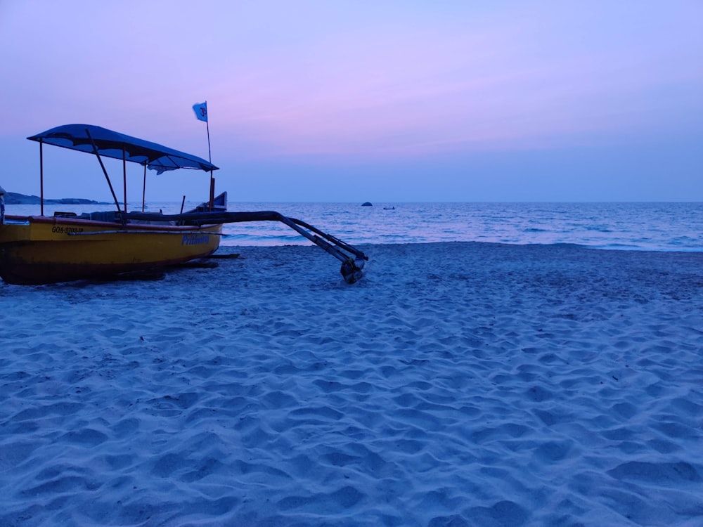 yellow and black boat on beach during daytime