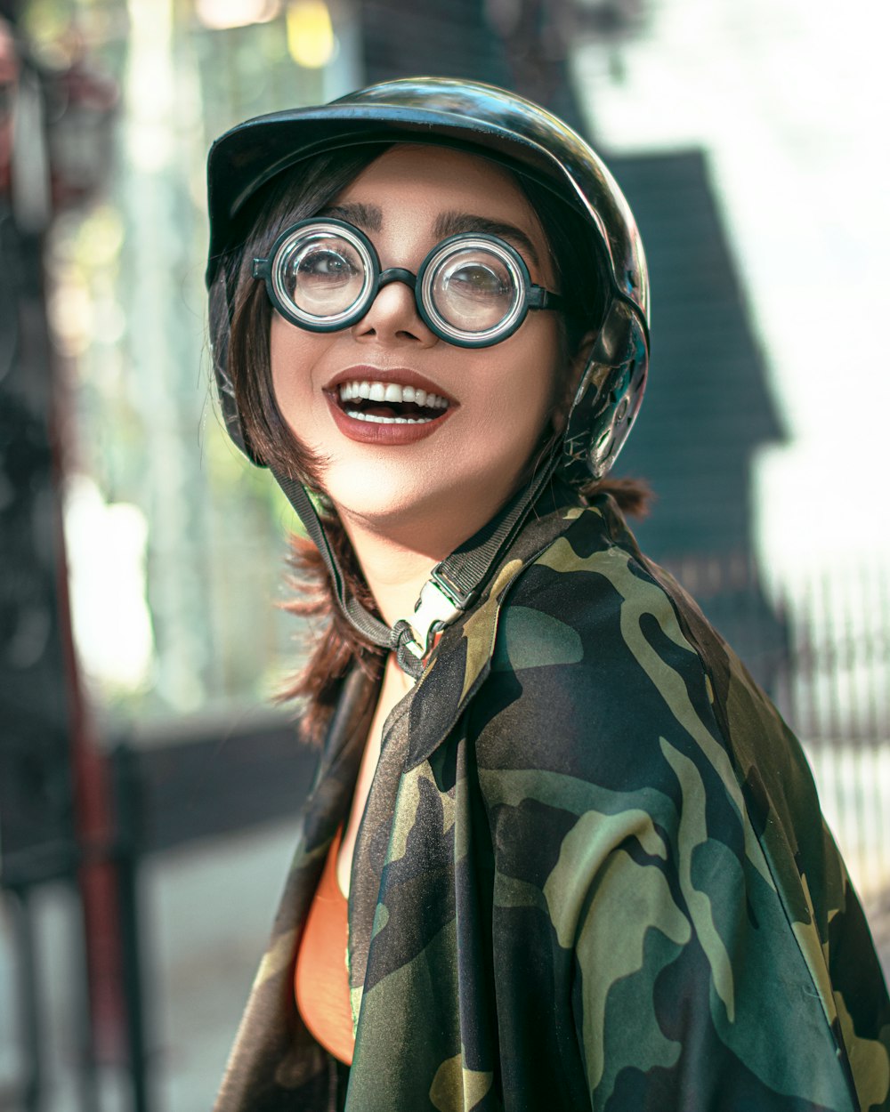 Mujer con chaqueta de camuflaje verde y marrón con gafas negras