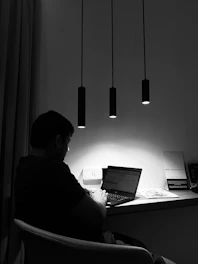 Photo of Cathy Secreto working at her minimalist desk with a laptop and notes, embodying focus and professionalism.