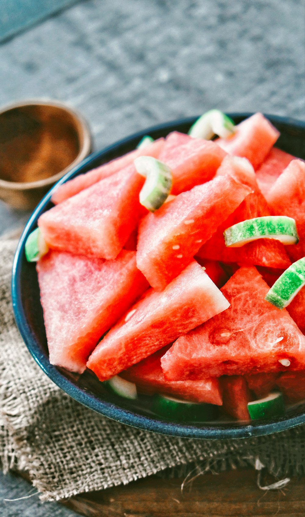 in Scheiben geschnittene Wassermelone auf schwarzem runden Teller