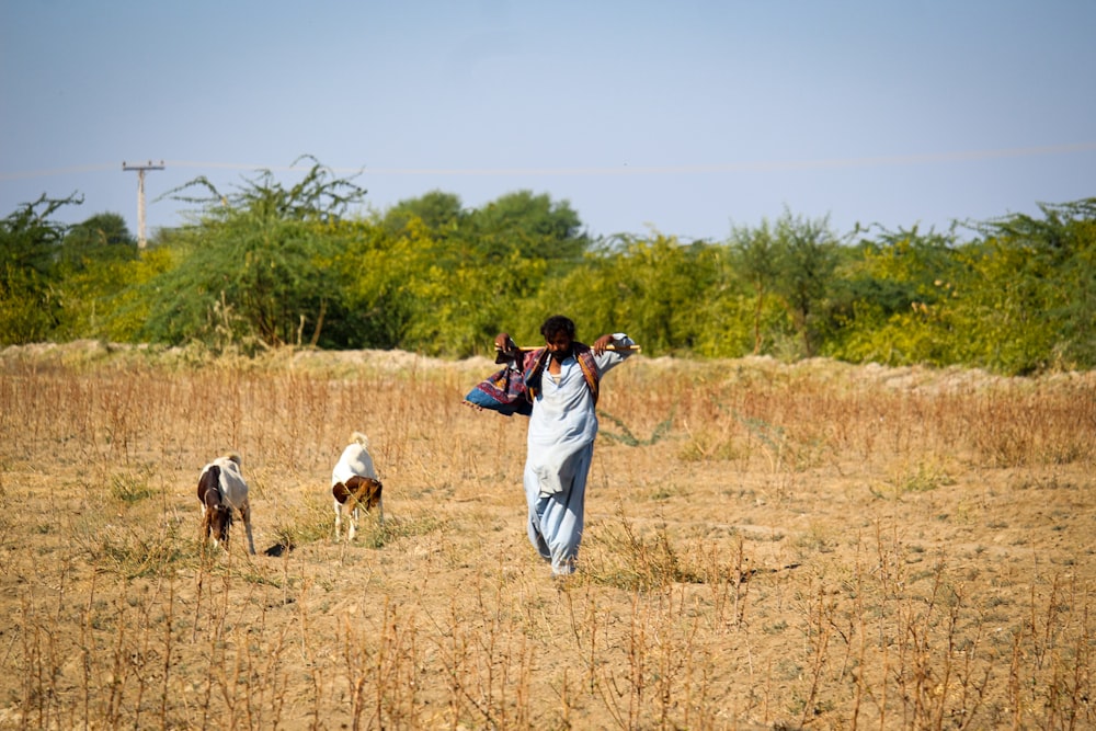 man in blue jacket and white pants carrying brown horse during daytime