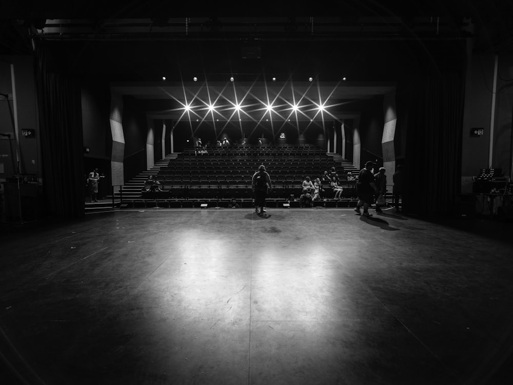 grayscale photo of people walking on hall