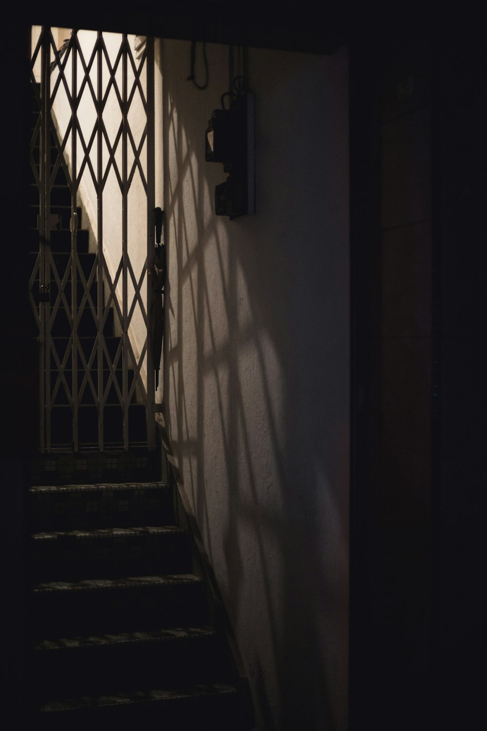 black metal gate on white concrete wall