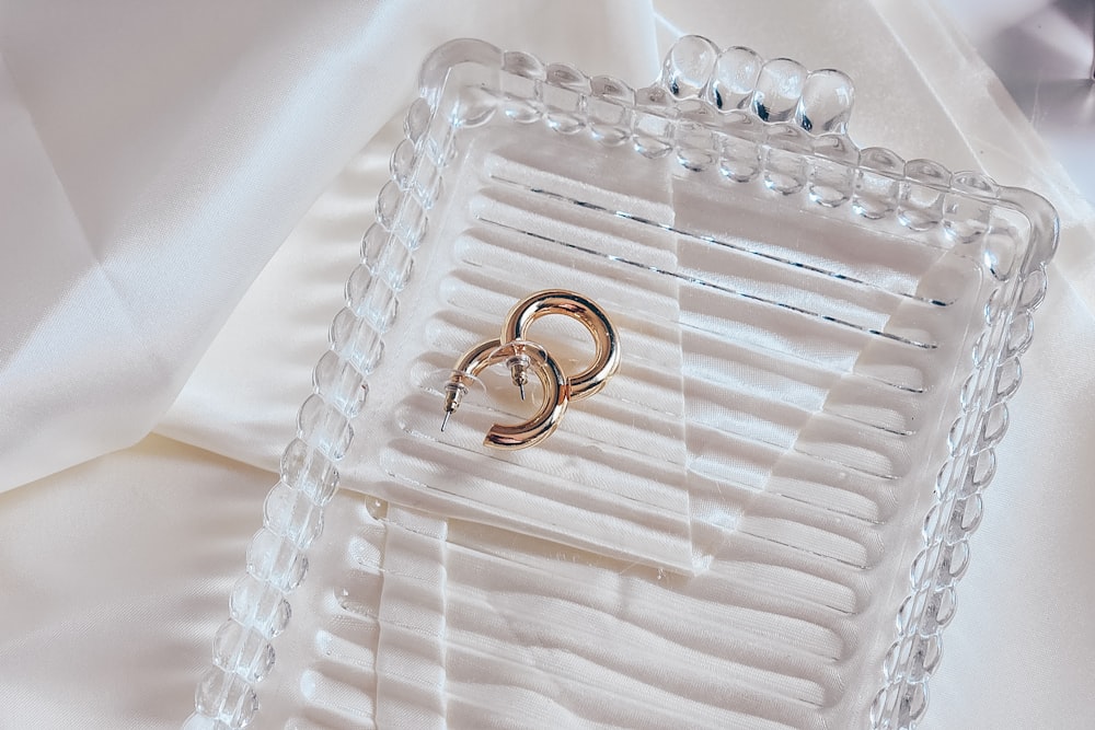 gold wedding band on white plastic tray