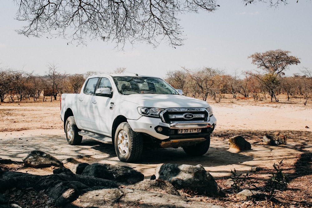 white chevrolet crew cab pickup truck on brown dirt road during daytime